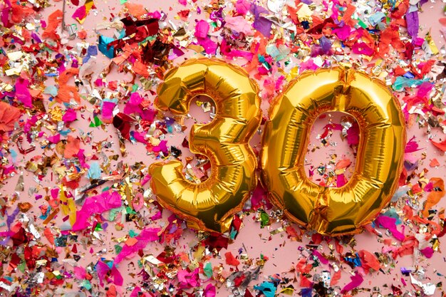 Number gold birthday celebration balloon on a confetti glitter background