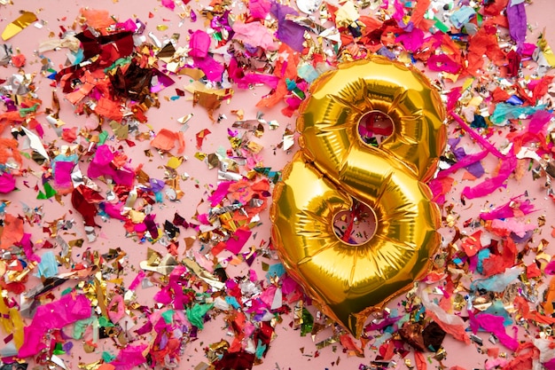 Number gold birthday celebration balloon on a confetti glitter background