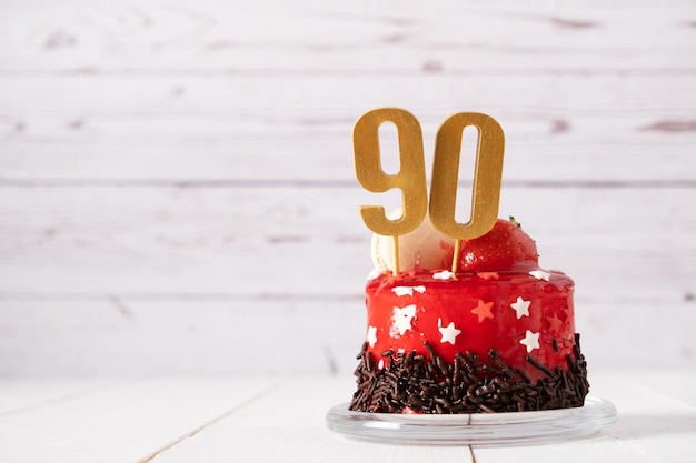 The number Ninety on a red birthday cake on a light background