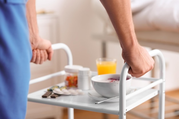 Nurse bringing patient39s food and medicine on serving trolley closeup Doctor39s prescription