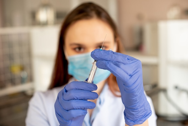 The nurse checks the syringe before vaccination. Vaccination against coronavirus