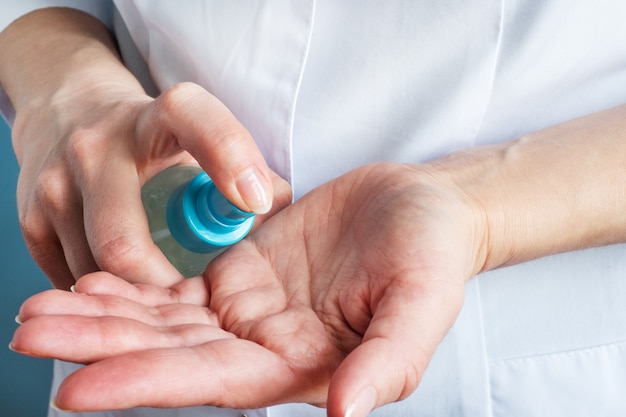 The nurse disinfects the hands with a cleaning solution.