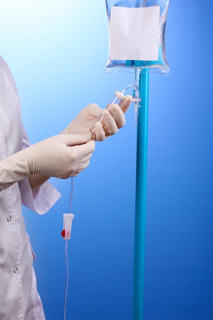 Nurse doing infusion on blue background