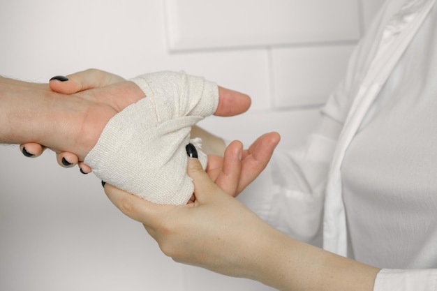 A nurse examines a man's injured arm tied with an elastic bandage a doctor's examination after an i