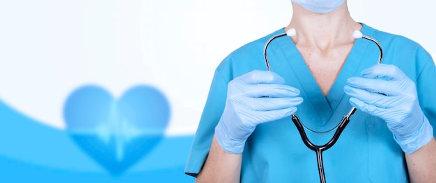 Nurse, female doctor with a stethoscope in her hands on a medical blue background. Healthcare banner. Copy space. High quality photo