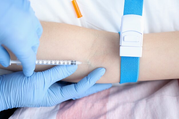 Nurse giving intravenous injection of medication to patient. Blood sampling from a vein concept