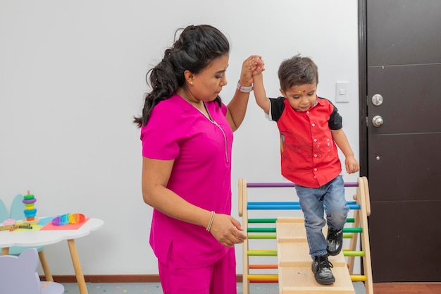 Nurse helping a child walk through a wooden game which is in her medical office