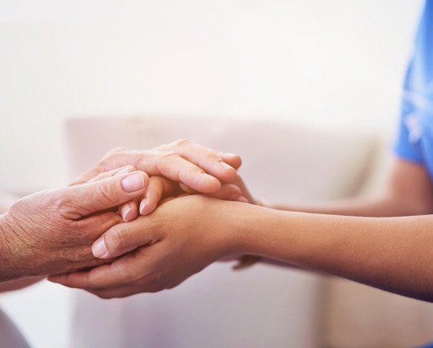 Photo nurse holding hands and senior support in house patient and trust for hope and compassion with medical employee caregiver nursing home and volunteer or consultation gratitude and people together