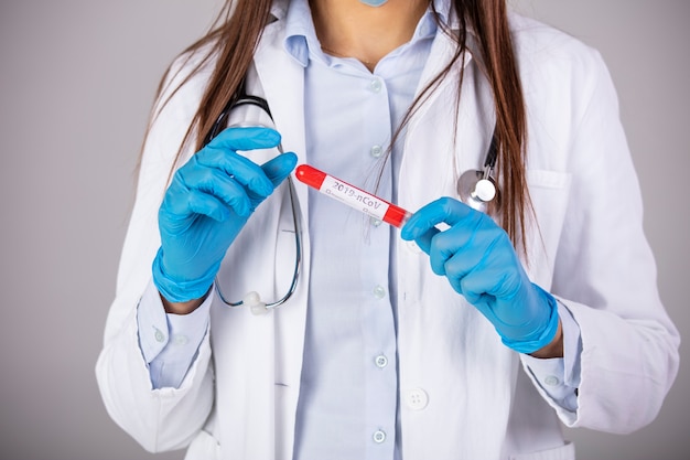 Nurse holding test tube with blood for 2019-nCoV analyzing. Novel Chinese Coronavirus blood test Concept. Blood test samples for presence of coronavirus (COVID-19) tube containing a blood sample