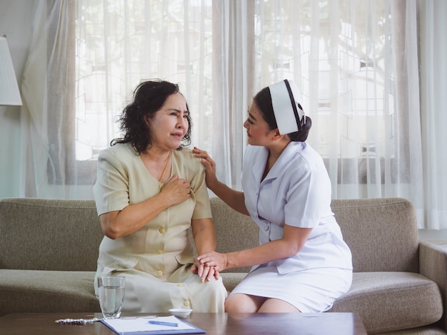 The nurse is caring for the elderly with happiness, Old women feel heart pain