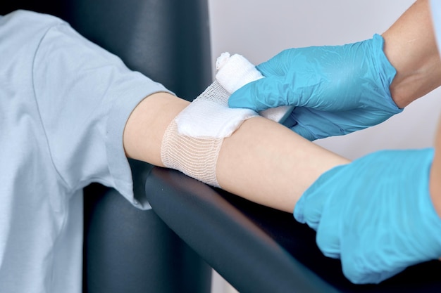 A nurse makes a bandage on her arm after the injection