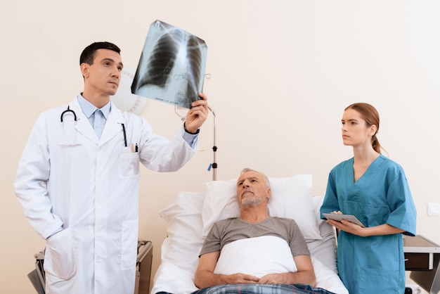 The nurse and the old man also examine the picture.