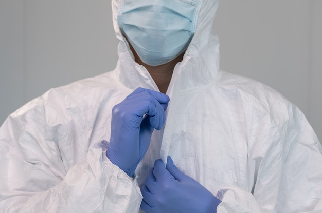 A nurse prepares by putting on protective suit during coronavirus pandemic. Nurse wears a PPE suit inside hospital or clinic