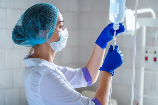 Nurse preparing drop counter to a patient for procedure in hospital