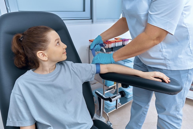 A nurse puts a tourniquet on a little girl's hand