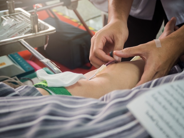 Photo nurse stabbing medical needles to donor arm. blood donor making donation