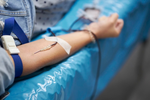 a nurse takes a blood sample. A Doctor Injecting Patient With Syringe To Collect Blood Sample