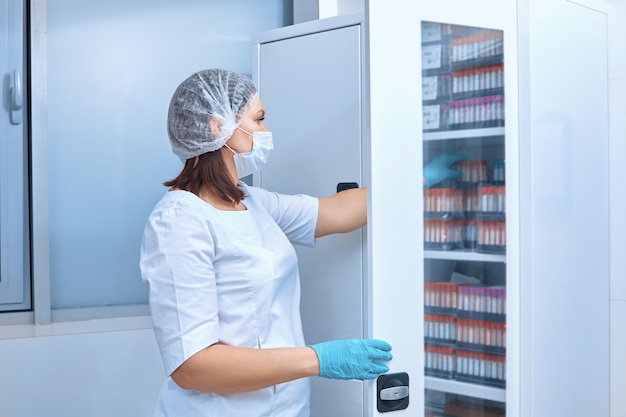 The nurse takes test tubes from the cabinet