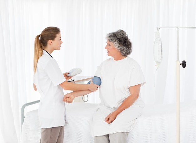 Nurse taking the blood pressure of her patient