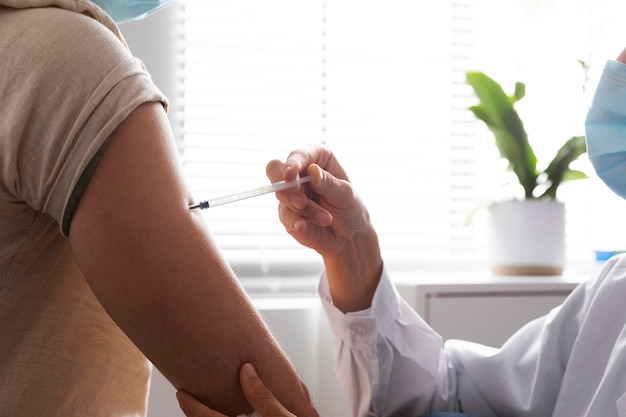 Nurse vaccinating a male patient