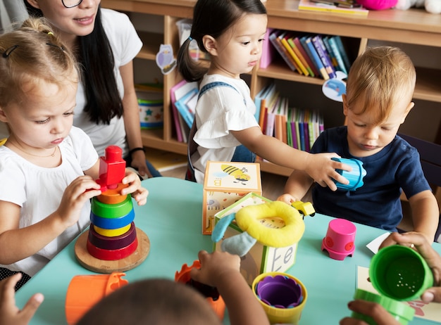 Photo nursery children playing with teacher in the classroom