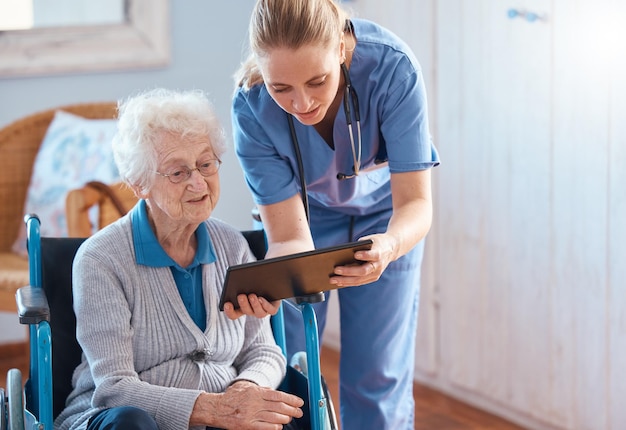 Nursing home woman or doctor with tablet checking medical results chart online or social media Healthcare tech and nurse caregiver help consulting with elderly patient in living room or bedroom