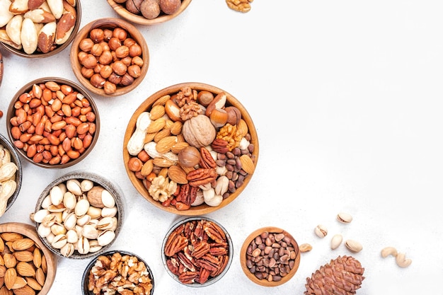 Nut mix in bowl Almonds hazelnuts walnuts and other Healthy food snack mix on white table top view copy space