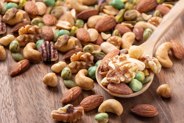 Nut mix on wooden spoon, Assorted and various of nuts Healthy diet.