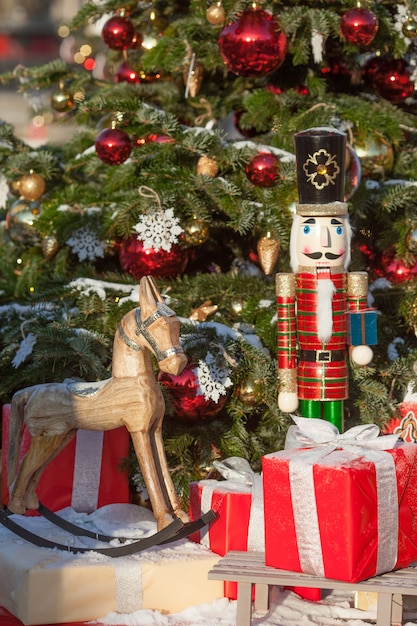 Nutcracker and wood horse at Christmas Market  in Winter Moscow, Russia. Advent Decoration and fir tree with Crafts gifts on the Bazaar. Christmas decoration on city street