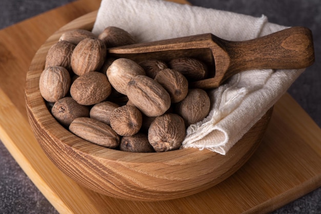 Nutmeg macro in a bowl. Nutmeg powder. Nutmeg spice in a wooden spoon.