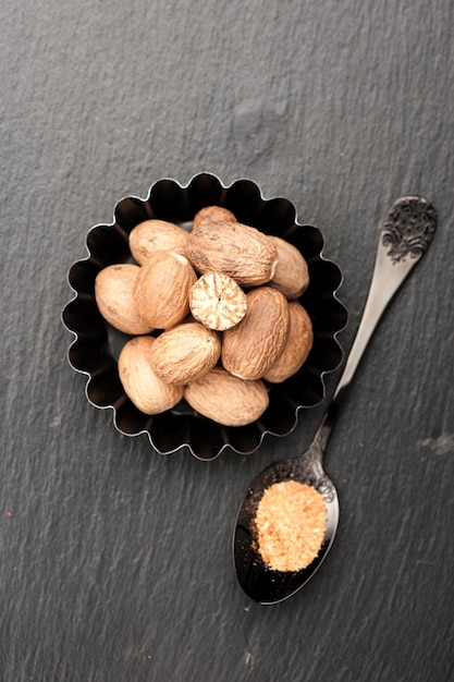 Nutmeg spice on a black background Top view vertical