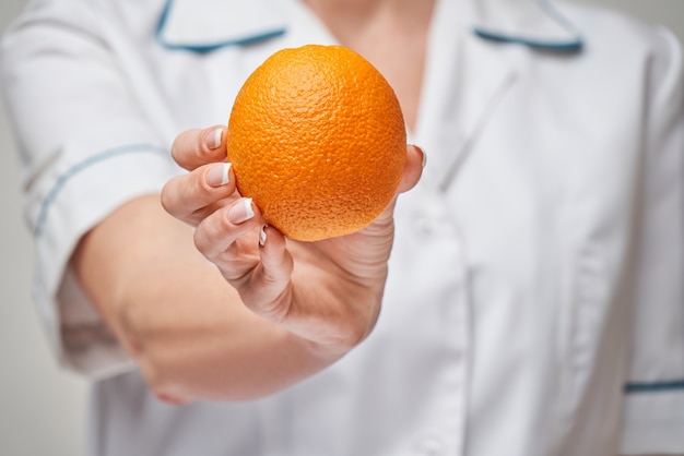 nutritionist doctor healthy lifestyle concept - holding fresh organic orange fruit