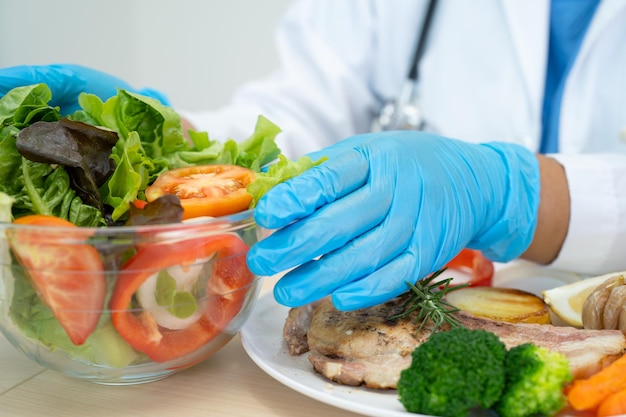 Nutritionist doctor holding various healthy fresh vegetables for patient