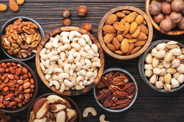 Nuts in assortment Walnuts pecans almonds and other Healthy food snack mix on wooden table background top view