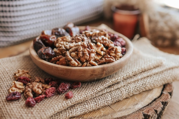 Nuts dates and cranberries in a wooden plate top view