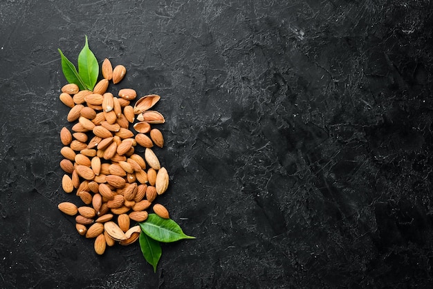 Photo nuts protein almonds on black stone background top view free space for your text