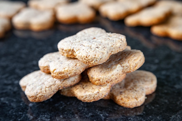 Nuts stack cookies. A lot of walnut cookies lies on a dark marble table. Homemade food.