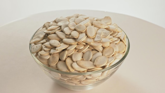 Nuts unpeeled pumpkin seed rotate are on a table in a plate Snack in transparent dish