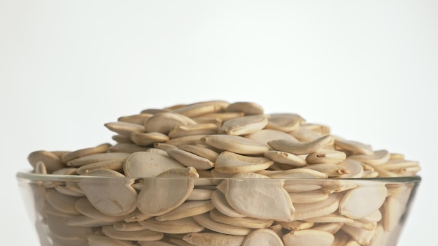 Nuts unpeeled pumpkin seed rotate are on a table in a plate Snack in transparent dish