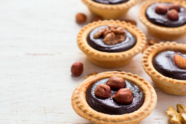 Nutty chocolate small tarts on a white background