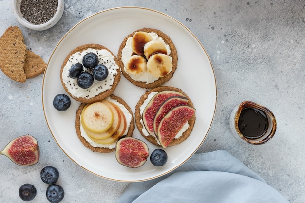 Oat crispbread with cream cheese banana blueberry pear fig and date syrup Healthy breakfast