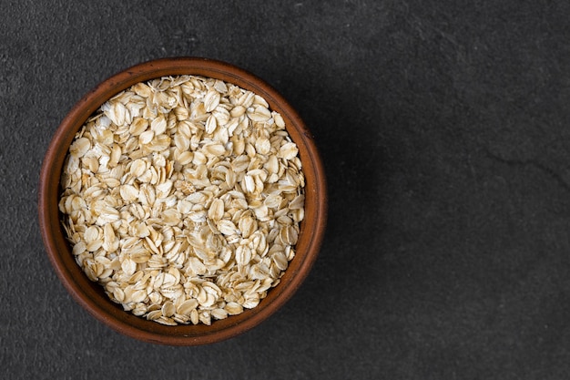 Oat flakes in a bowl on the old board Healthy eating