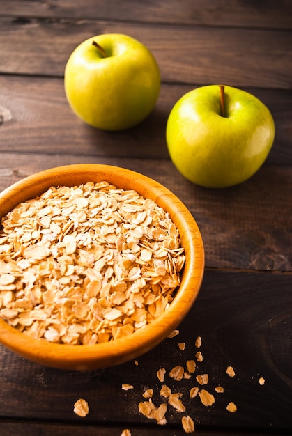 Oat flakes in bowl and two apples