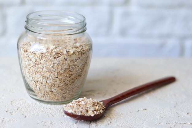 Oat flakes in a glass jar, healthy balanced breakfast