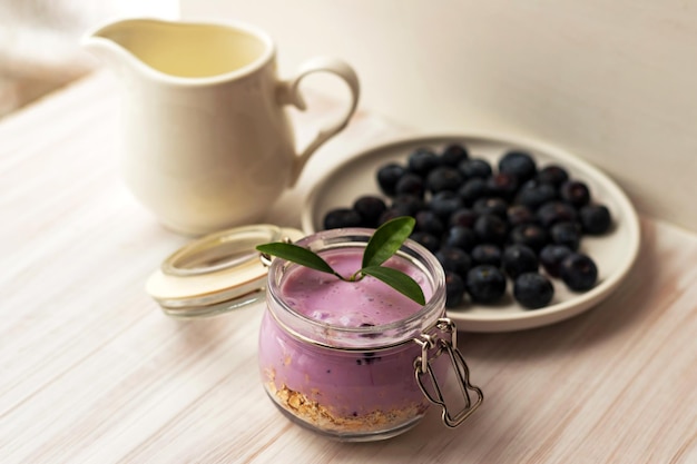 Oat flakes granola or muesli with homemade yogurt smoothie fresh blueberry and ceramic jug milk