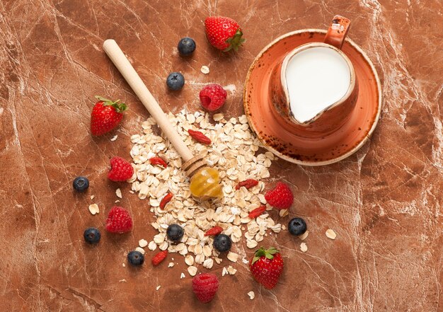 Oat flakes milk honey and berries Food background