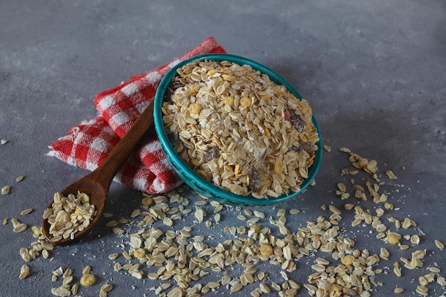 Oat flakes uncooked in a green bowl on rustic table Healthy food for breakfast