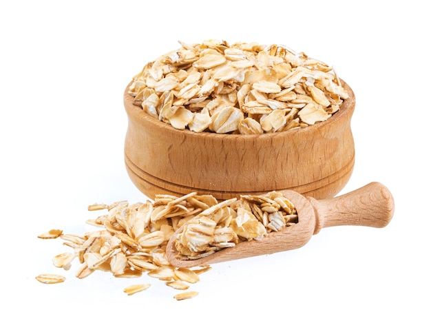 Oat flakes in wooden bowl isolated on white background