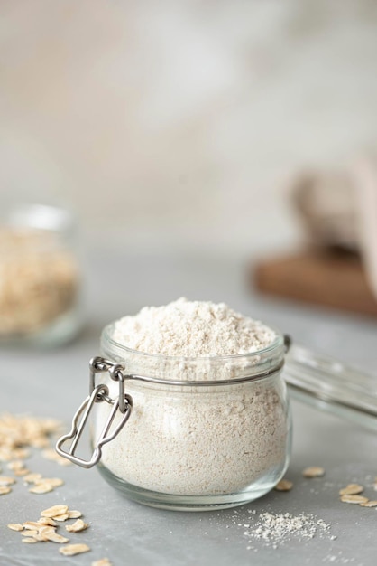 Oat flour in a glass jar on a white table