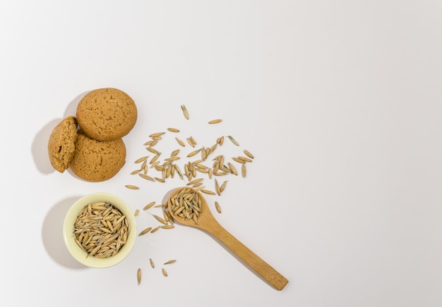 Oat grains on a white background in a wooden spoon. Copy space, horizontal background